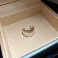 Detailed close-up of a silver ribbed ear cuff nestled in a premium velvet jewelry box. - Striped Texture Style (HE32236) / Silver