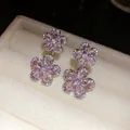 Detailed macro view of silver needle earrings featuring pink zircon flower charms - Floral Style (HE31782) / Pink