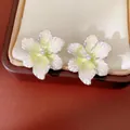 Close-up of elegant flower stud earrings with pearly white petals and zircon centers - Style 10