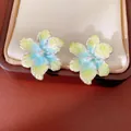 Macro view of delicate gradient yellow and blue flower stud earrings with center zircon - Style 11