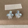 Dettaglio di orecchini a fiore in smalto blu con nappe di cristallo scintillanti. - Stile Nappina in Cristallo con Fiore e Perno in Argento / Blu