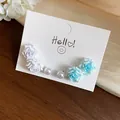 Detailed macro shot of elegant resin rose flower and pearl stud earrings set on a white card - Purple Sky Blue Flower Pearl Set / 6-Piece Set / White-Blue