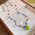 Vue détaillée d'un collier en perles et étoiles avec un pendentif en émail vert vif. - Collier Perle Étoile Pomme / Argent & Vert