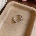 Silver open ring with square gemstone and clear beads on textured tray background - Silver