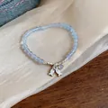 Close-up detail of a light blue beaded bracelet featuring delicate silver fish pendants. - Silver Blue
