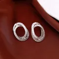 Elegant silver-toned earrings with brilliant zirconia stones on a brown fabric background - Style 14