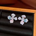 Elegant flower stud earrings featuring colorful resin petals and pearl center in a jewelry box - Style 15