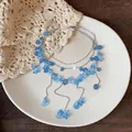 Detailansicht der frischen blauen Blumen-Mehrschichtkette mit süßen Tropfenquasten. - Blumen-Quasten-Stil / Silber-Blau