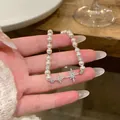 Close-up detail of elegant pearl bracelet with sparkling zircon star charms on hand. - Silver