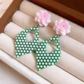 Close-up detail of pink resin flower earrings with green polka dot diamond-shaped drops - Pink-Green-White