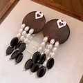 Detailed close-up of vintage wood and pearl tassel earrings with heart accent. - Round Hollow Heart Style (Silver Post) / Coffee-White-Black