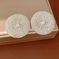Primer plano de pendientes redondos plateados de gran tamaño con micro-pavé de strass - Plateado