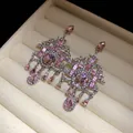 Vista macro dettagliata di orecchini vintage a lampadario con brillanti strass rosa vivaci - Placcato Argento Rosa