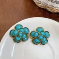 Detailed macro view of vintage flower stud earrings featuring turquoise resin and gold frames - Floral Style (HE32597) / Gold-Blue