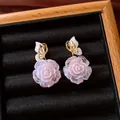 Elegant pink rose earrings with gold butterfly detail displayed in a black jewelry tray - Style 38