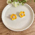 Macro detail view of elegant yellow enamel flower stud earrings with zircon and pearl centers - Drop Oil Flower Style (HE33778) / Yellow