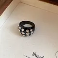 Detailed macro view of a chunky black resin ring with metallic silver studs on a tray - Rivet Decorated Ring