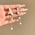 Detail view of elegant colorful polka dot flower tassel earrings with white pearls. - Colored Polka Dot Iris Tassel Style