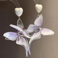 Macro detail of ethereal purple fabric butterfly wings attached to white heart studs - Butterfly Earrings (71#) / White and Purple (71#)