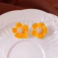 Vibrant yellow floral stud earrings with sparkling zircon centers on a white ceramic plate - Style 53