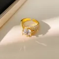 Macro detail of an elegant gold twisted open ring featuring a large sparkling zirconia - Gold