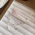 Detailansicht einer rosa Chiffonblumen-Halskette mit Perlenakzenten in einer Schmuckschale - Halskette-Rosa