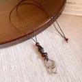 Close-up detail of a vintage ethnic long necklace featuring wooden beads and resin pendant - Oval Pendant Style