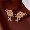 Elegant floral stud earrings featuring pink zircon petals and a central pearl accent. - Style 70