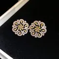 Close-up of hollow floral earrings with yellow stones in a black velvet jewelry box - Silver