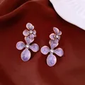 Elegant purple flower stud earrings with zircon crystals and gold-tone finish on brown fabric - Style 73