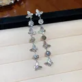 Close-up of butterfly tassel earrings with zircon stones and 18k gold plating - Silver