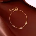 Dettaglio di un bracciale vintage dorato con tre zirconi viola su sfondo di seta - Stile Ovale Viola / Oro