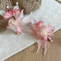 Close-up of two pink fabric flower hair clips with pearls on a linen background. - Duckbill Clip (1 Pair) / Pink