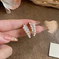 Primo piano di eleganti orecchini placcati oro 18k con perle e zirconi scintillanti - Oro-Bianco