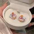 Detalle de pendientes geométricos con cristales de colores y perla en caja blanca - Estilo Zirconia Cuadrada / Plata-Rosa