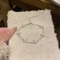 Close-up detail of silver cross bracelet featuring pearls and sparkling crystals - Bracelet - Silver