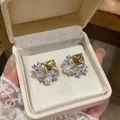 Detail shot of elegant yellow square zircon butterfly stud earrings with pearl in a jewelry box - Green