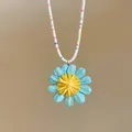 Dettaglio macro di una collana con ciondolo a margherita estiva e perline. - Blu Multicolore