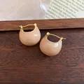 Close-up of minimalist beige enamel bean hoop earrings on a wood background. - Enamel Bean Style (HE10919) / Huggie-Light Khaki