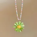 Dettaglio di un ciondolo a margherita verde su una collana di perline colorate - Verde Multicolore