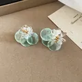 Detailed view of mint green floral drop earrings with clear petals and gold bead centers - Flower and Shell Mix