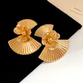 Detailed view of vintage gold fan-shaped metal earrings with central flower design - Gold