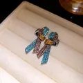 Primer plano de pendientes de nudo vintage con pedrería de colores y aguja de plata. - Multicolor