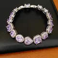 Close-up of elegant purple cubic zirconia bracelet with various stone shapes on leather background - Purple
