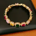 Close-up of elegant gold-plated bracelet with multi-colored oval and square zircons. - Colorful