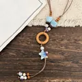 Detailed close-up of ethnic style necklace with blue ceramic stars and wooden rings - Coffee-Blue