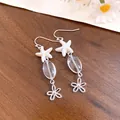 Close-up of beach style starfish and glass bead drop earrings with flower charm details - Starfish Flower Drop Style (HE34311) / Silver