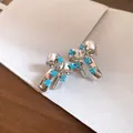 Detailed macro view of silver bow-knot stud earrings with light blue flower accents - Silver Post Bowknot Flower Studs / Silver-Blue