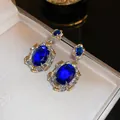 Close-up of vintage palace style earrings with blue oval zircons and gold accents - Palatial Oval Stud (HE16439) / Silver Needle / 5# Silver Gold Blue