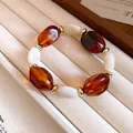 Detailansicht eines Acrylperlenarmbands mit bernsteinfarbenen und weißen Perlen - Armband / Kaffee Und Weiß Spleißen
